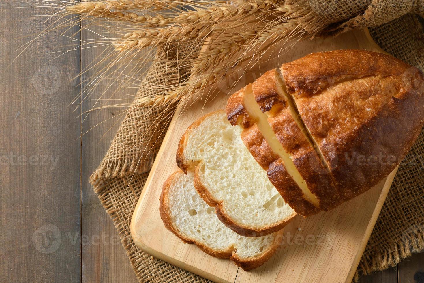 Sliced of fresh homemade french breads on wood background, photo