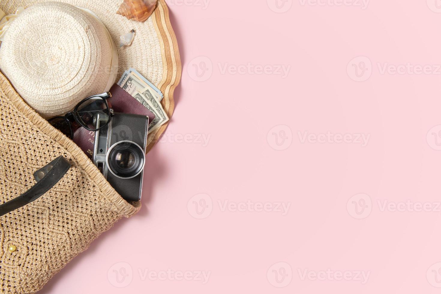 Traveler accessories, beach hat with retro film camera, sunglasses, money and passport in handmade knitted bag photo