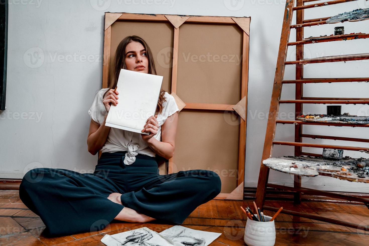 portrait of a beautiful young artist, draws pictures in the workshop photo