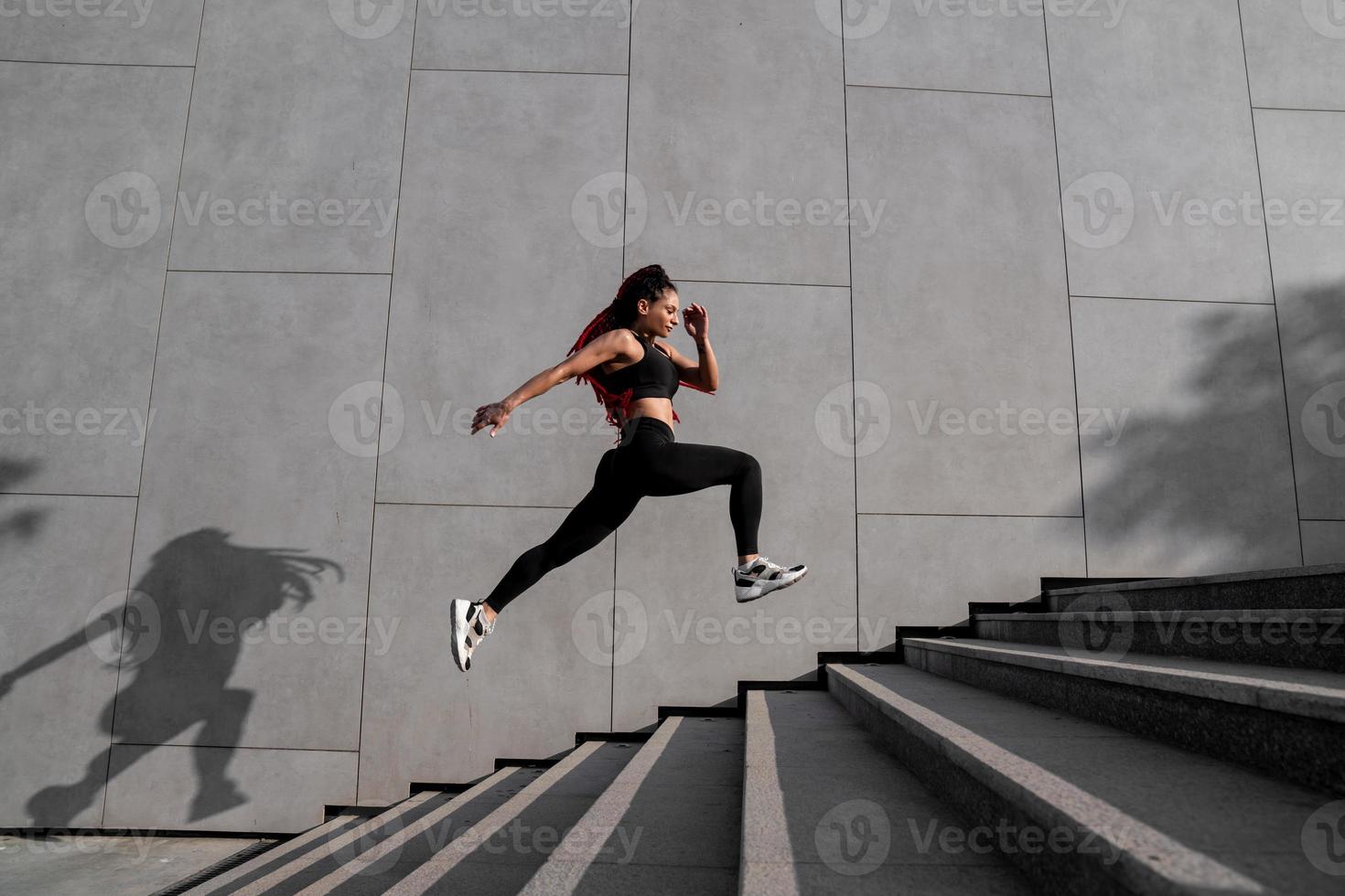 Fit young woman jumping and running photo