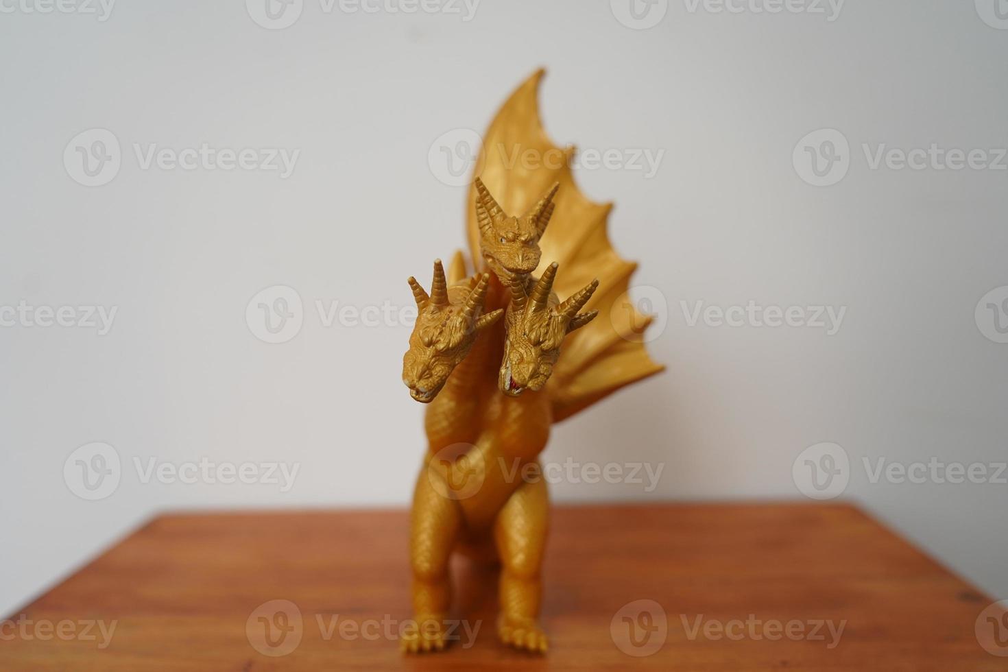 golden dragon ghidorah isolated on white background. On wooden table photo