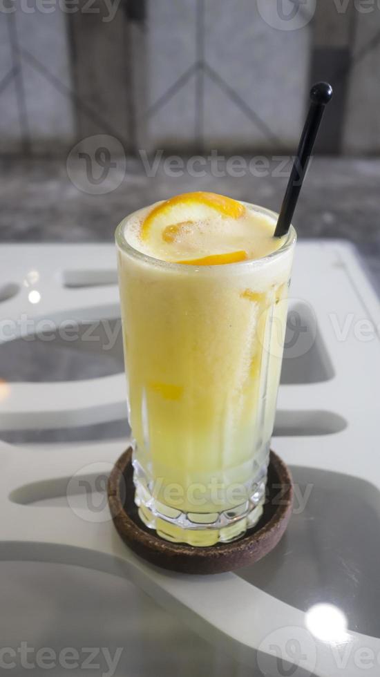 Ice squeezed orange or orange juice in a tall glass at the table photo