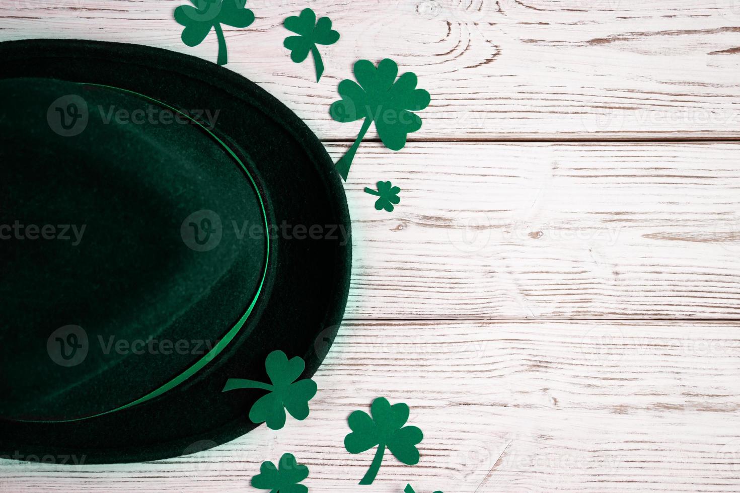 Leprechaun hat and shamrock clover leaves on white background. Happy St. Patrick's Day. photo