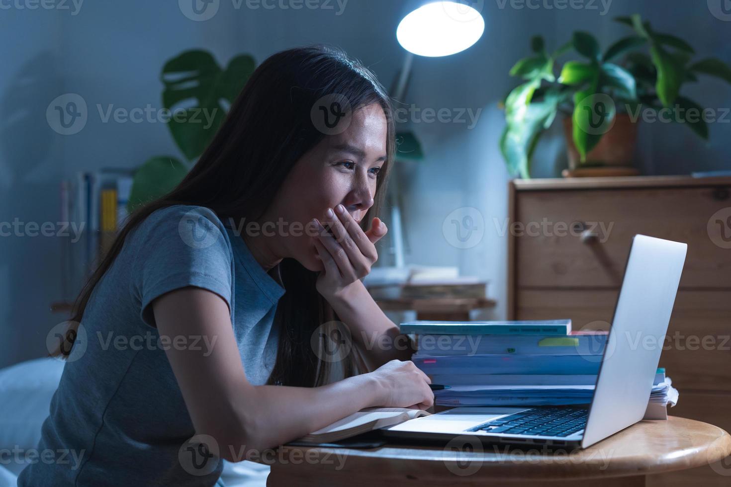 wfh, asiático joven estudiante mujer bostezando cubierta boca, estudiar en línea sentado en escritorio a hogar, haciendo deberes conectando a Internet en ordenador portátil computadora, estudiando tarde a noche, aprendizaje y educación. foto