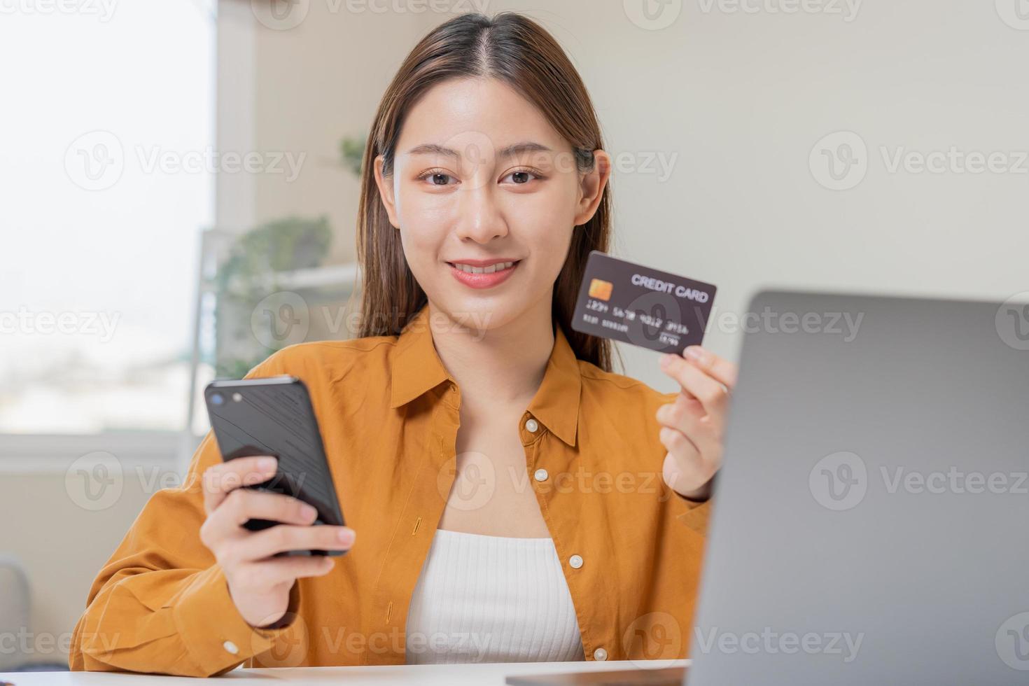 conveniencia en línea Internet bancario, sonrisa asiático joven mujer mano en participación crédito tarjeta a pago gasto por escanear qr código a transferir o pagar dinero sin efectivo a hogar. tecnología de financiero. foto