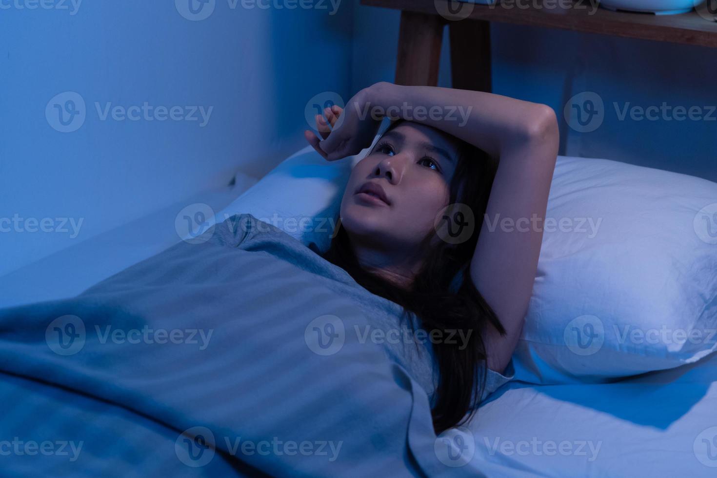 Stressed person. Asleep, sleep asian young woman, girl under blanket, suffering from insomnia, awake at night in bedroom, tired and exhausted. Frustrated people with problem, exhausted on nightmares. photo