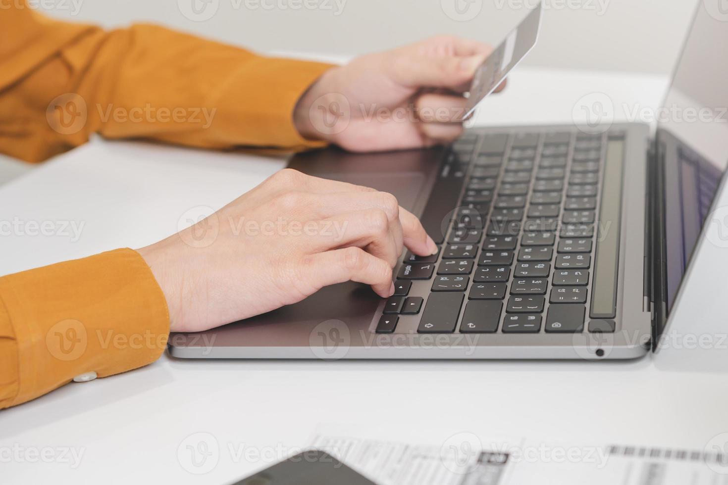 Internet banking, Online shopping at home, asian young woman hand in typing on keyboard, holding credit card, using laptop computer, spending money with purchase on store at home. Shopaholic ecommerce photo