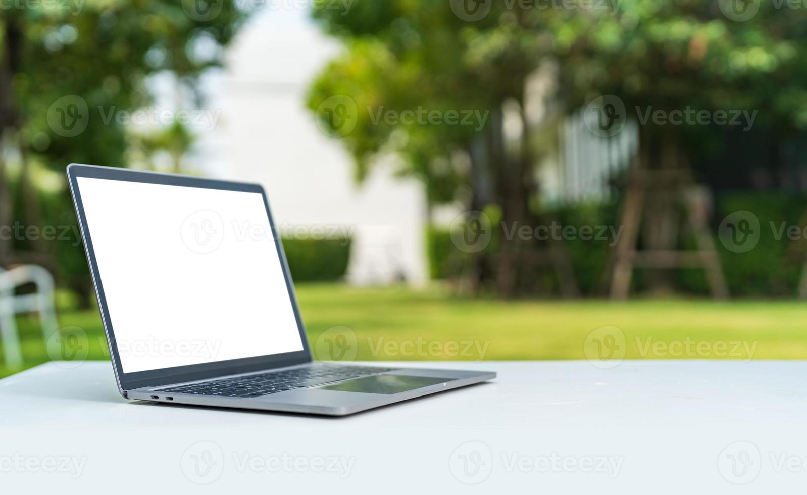 Computer laptop with blank back screen on the table in the garden photo