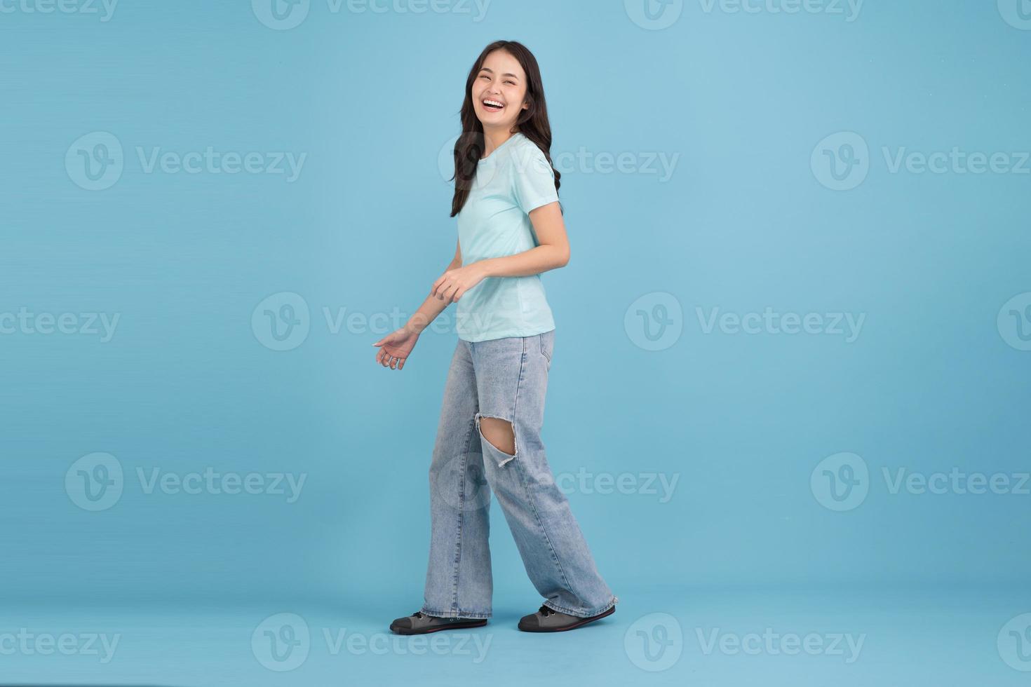 Beautiful woman walking On a blue background, she is happy. photo