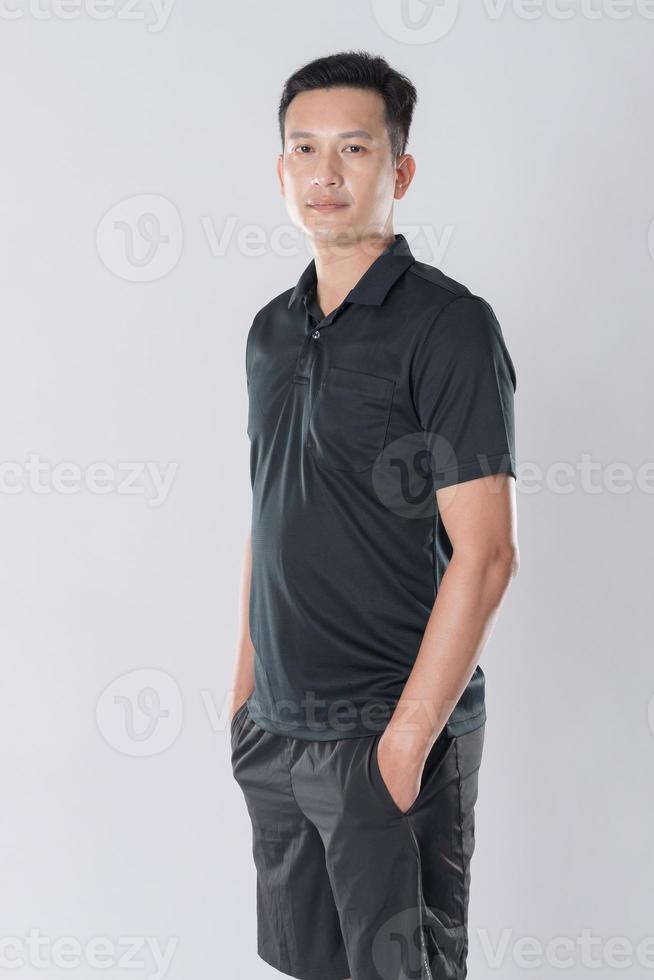 Elegant young man in black shirt standing on white background photo