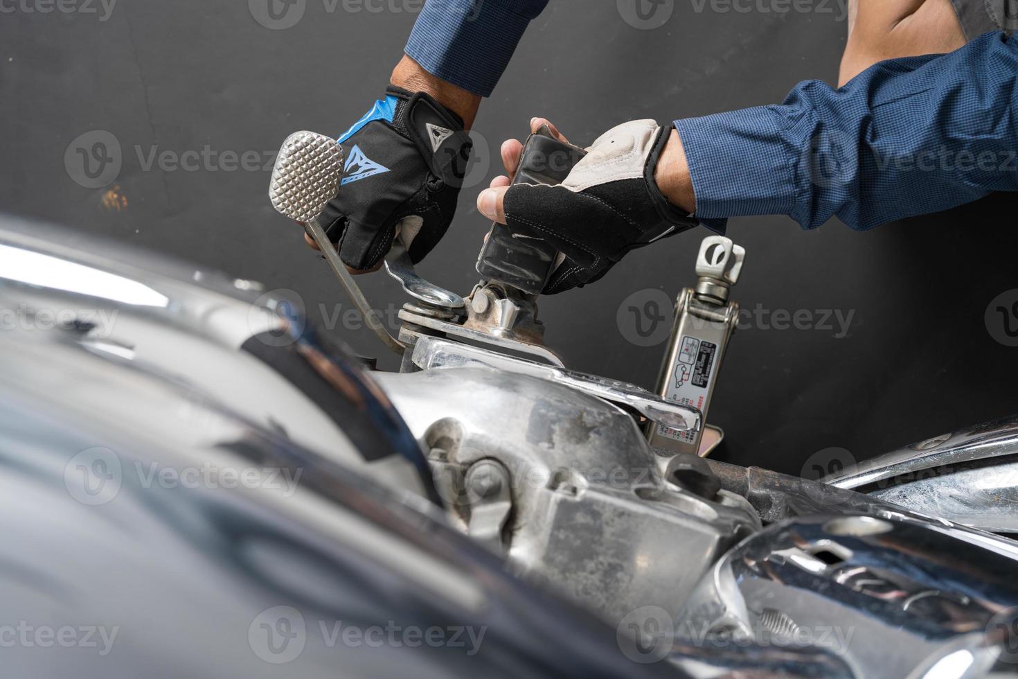 People are repairing a motorcycle Use a wrench and a screwdriver to work photo