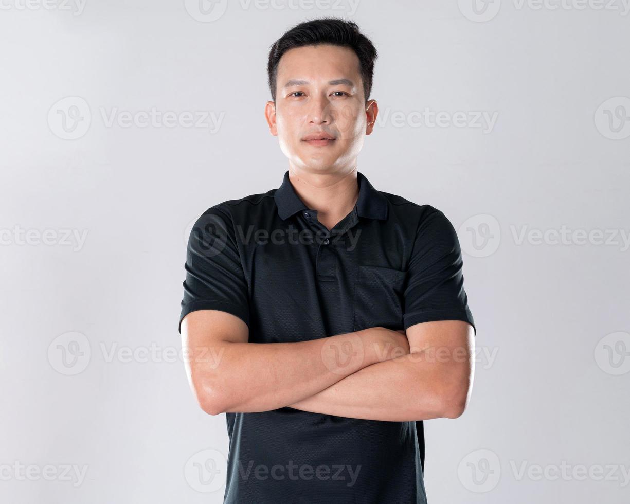 Elegant young man in black shirt standing on white background photo
