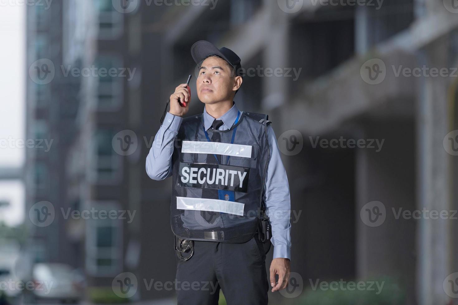 Male security guard using portable radio photo