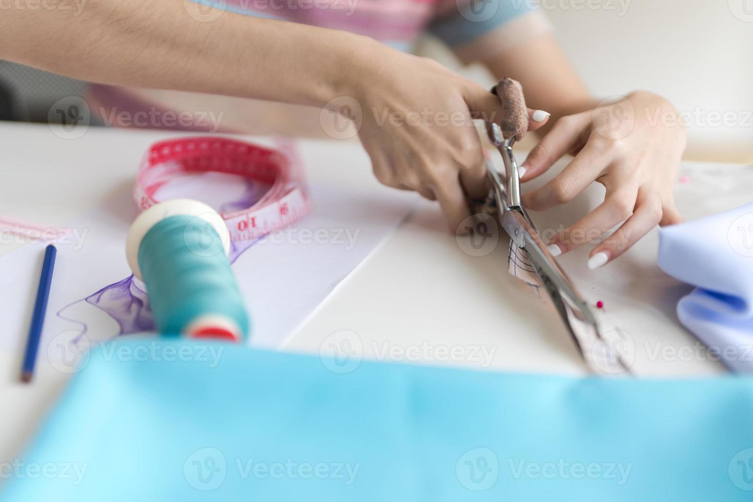 Cropped image of young beautiful designer working with sketches and tools. photo