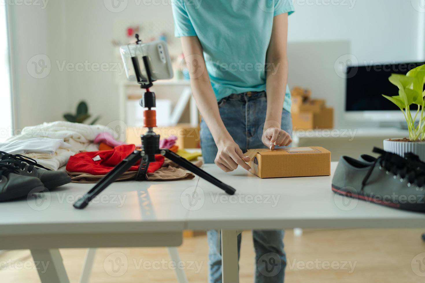 A young woman owner of a small e-commerce business is packing items into the mail box. photo