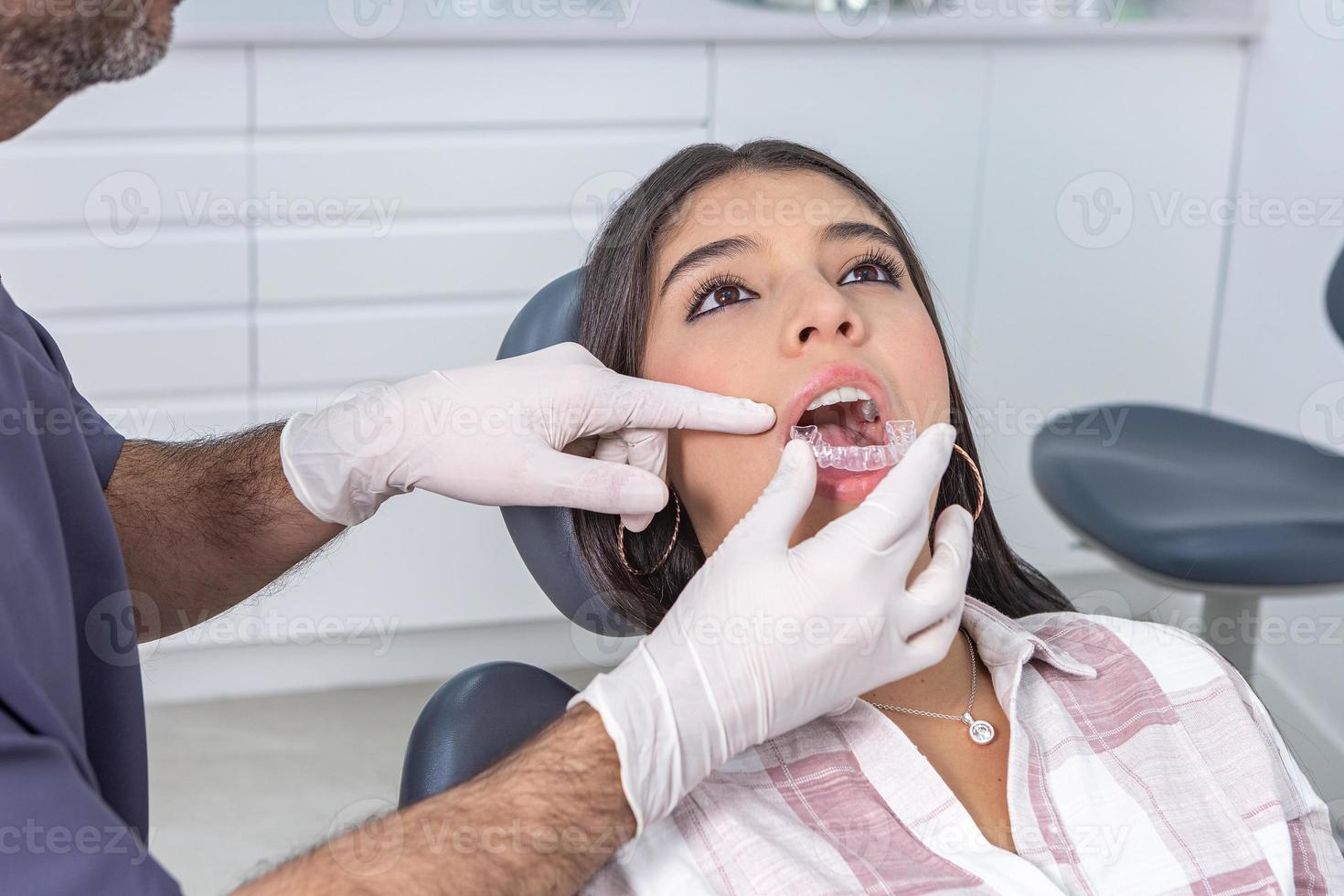 cosecha masculino estomatólogo adecuado dental alineadores en hembra paciente dientes foto
