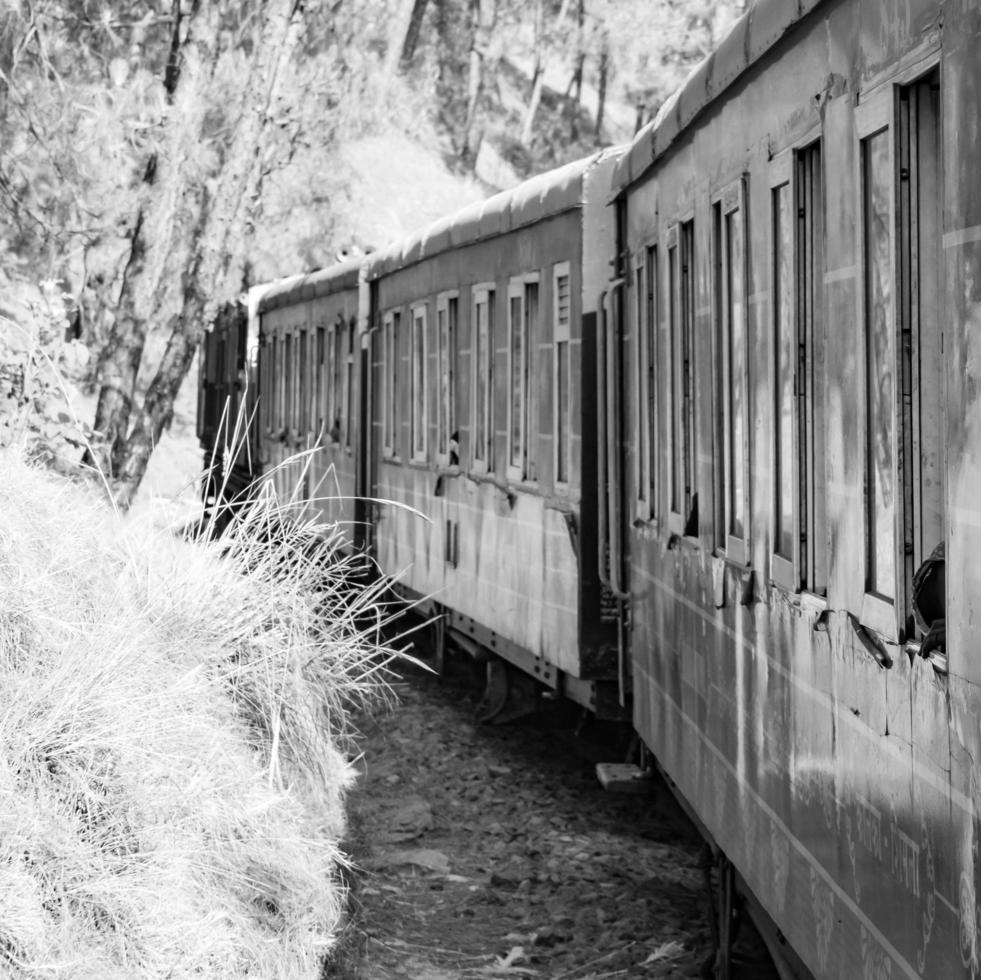 Shimla, Himachal Pradesh, India - May 14, 2022 - Toy train Kalka-Shimla route, moving on railway to the hill, Toy train from Kalka to Shimla in India among green natural forest photo