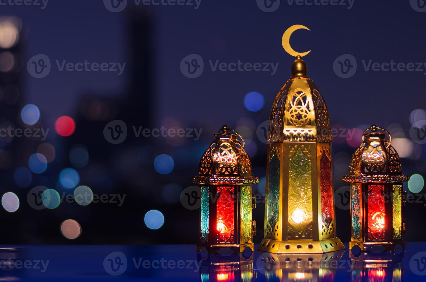 Selective focus on big lantern with night sky and city bokeh light background for the Muslim feast of the holy month of Ramadan Kareem. photo