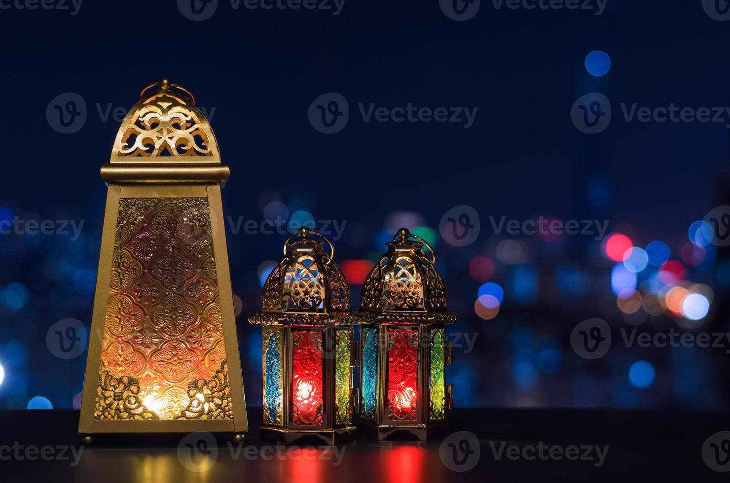 Selective focus on big lantern with night sky and city bokeh light background for the Muslim feast of the holy month of Ramadan Kareem. photo