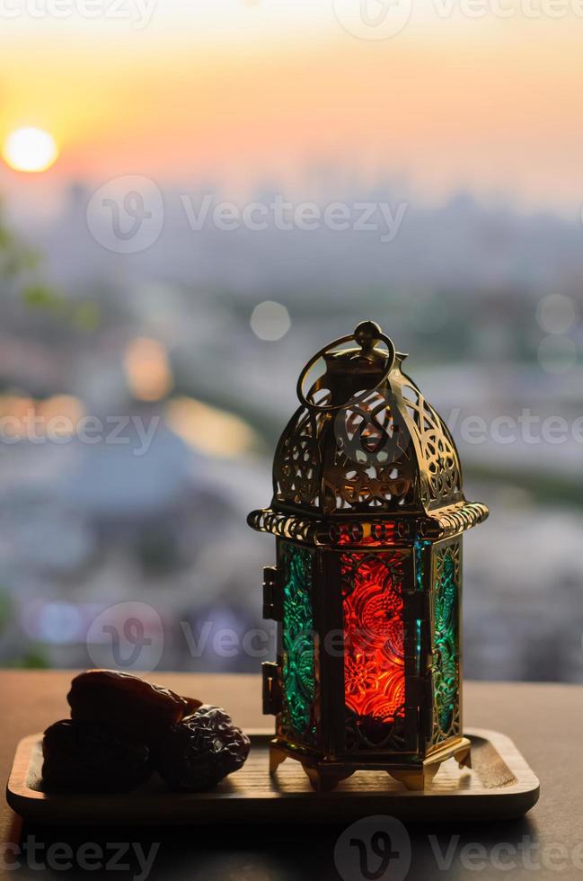 Lantern and dates fruit with dusk sky and city background for the Muslim feast of the holy month of Ramadan Kareem. photo