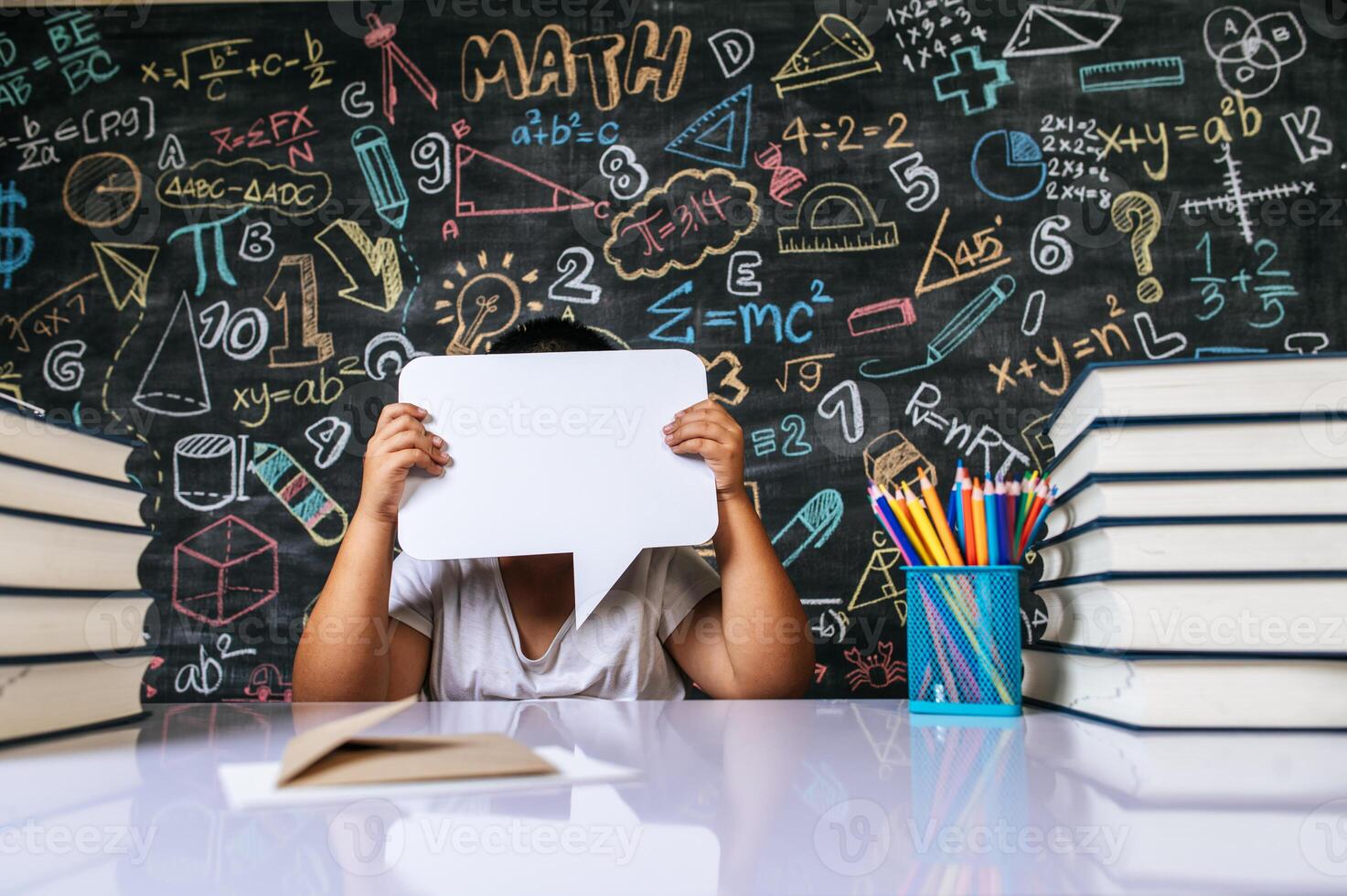 Child acting with speech bubble in the classroom photo