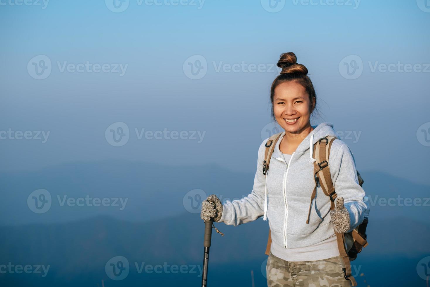 retrato de asiático caminante mujer con mochila mirando a cámara en montaña con Copiar espacio foto
