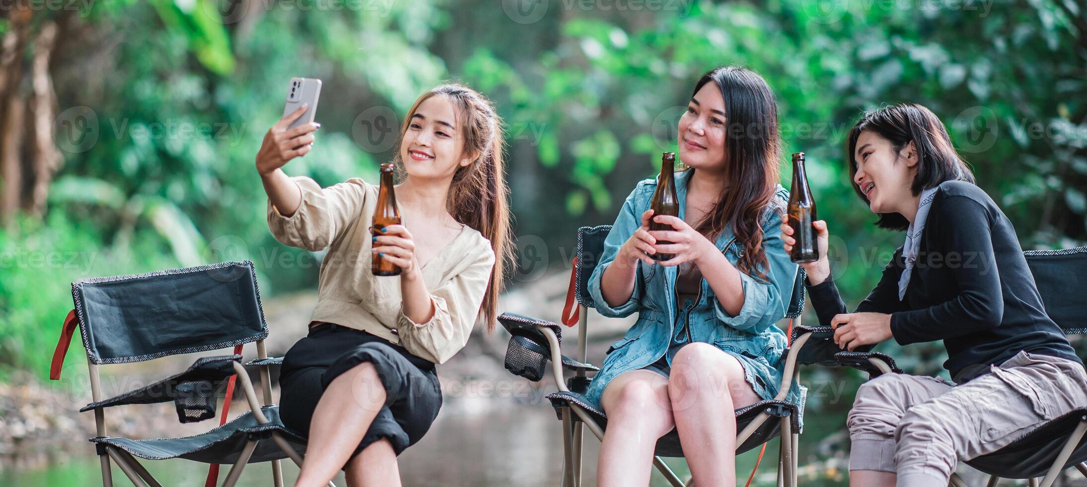 Young women drink beers and use smartphone take photo