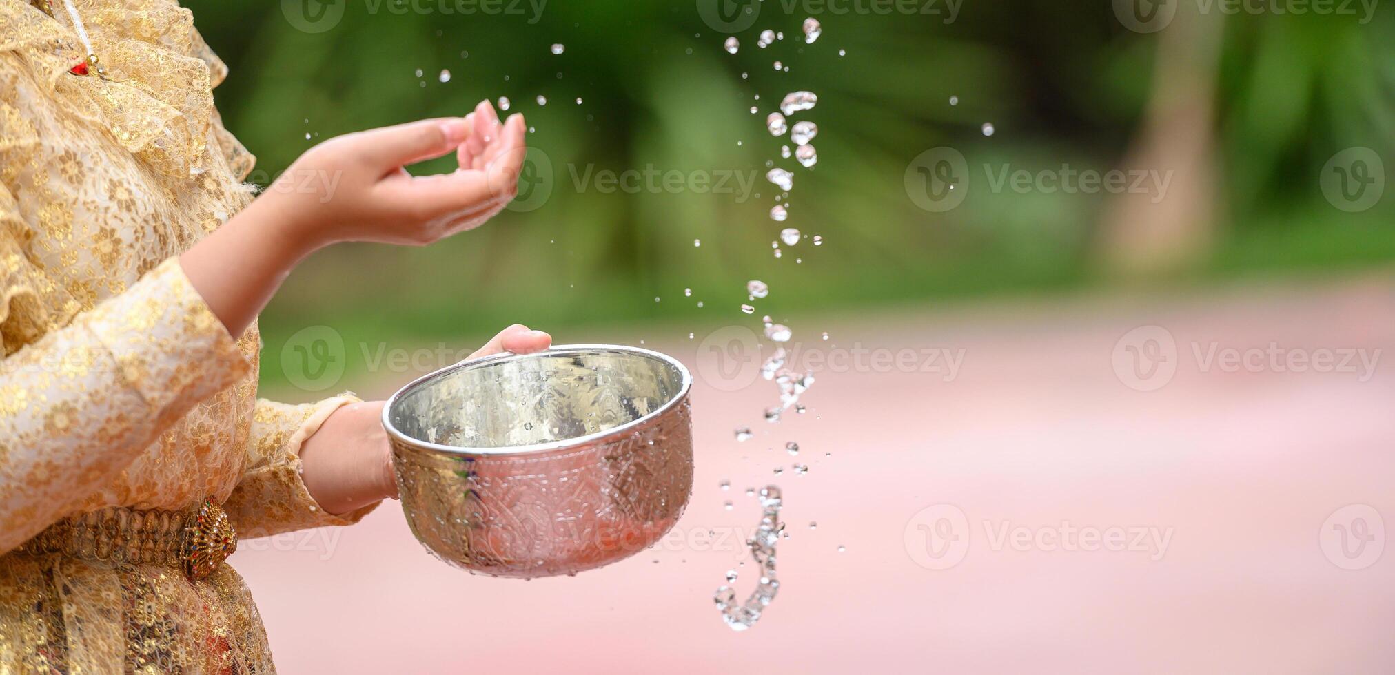 Female hands holding water bowl on Songkran festival photo
