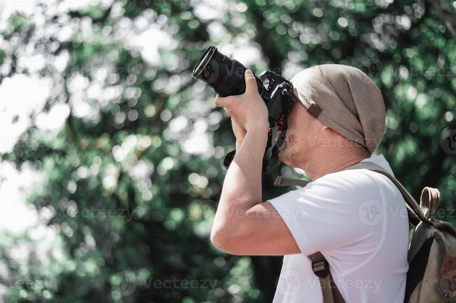 hombre viajero asiático con mochila tomando una foto en el parque