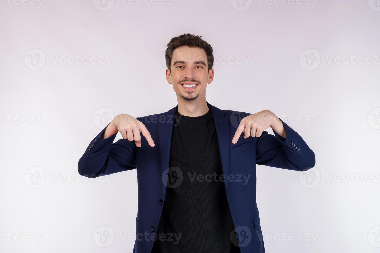 Portrait of young businessman pointing fingers at copy space isolated on white studio background photo