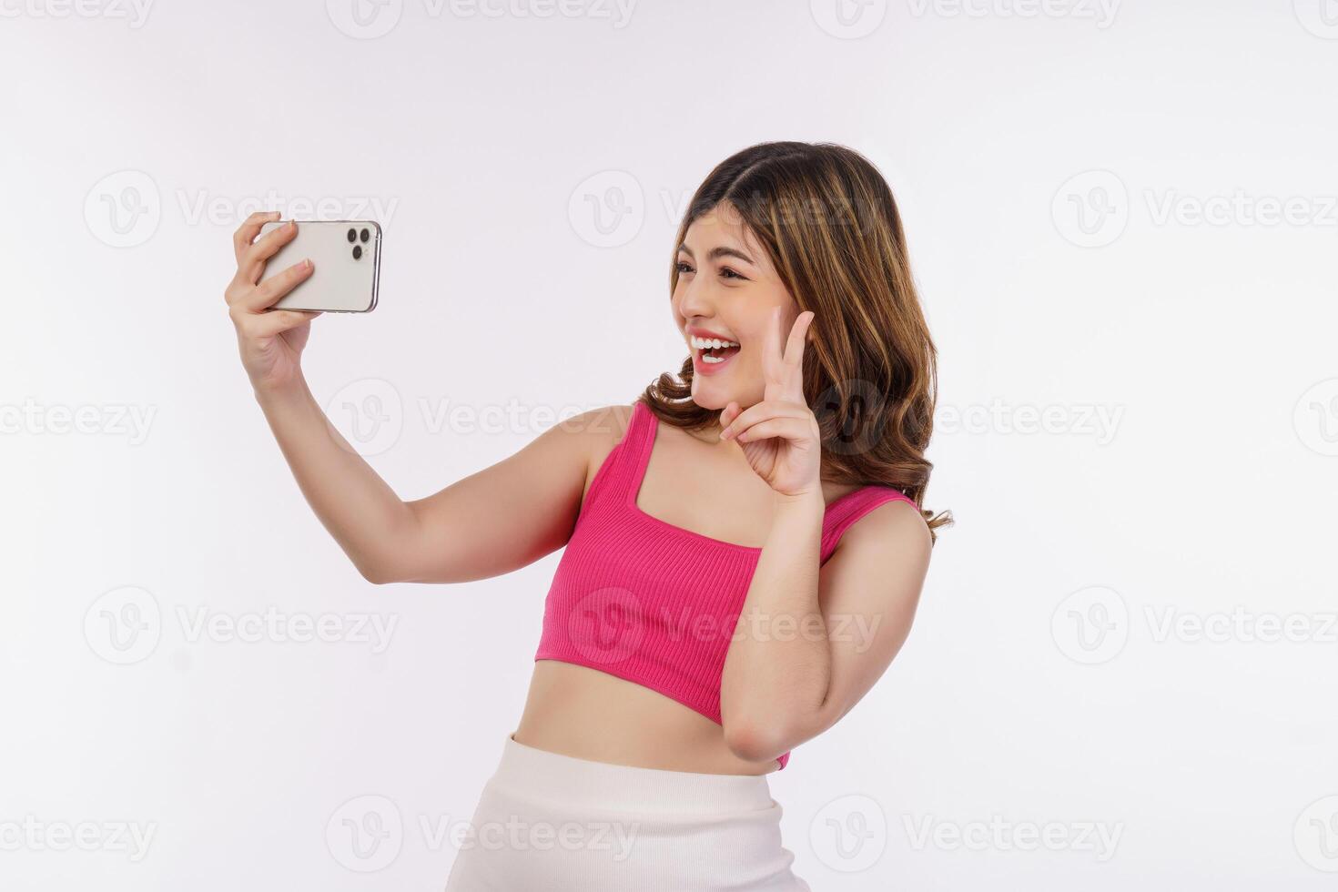 Portrait of happy smiling young woman selfie with smartphone isolated over white background photo