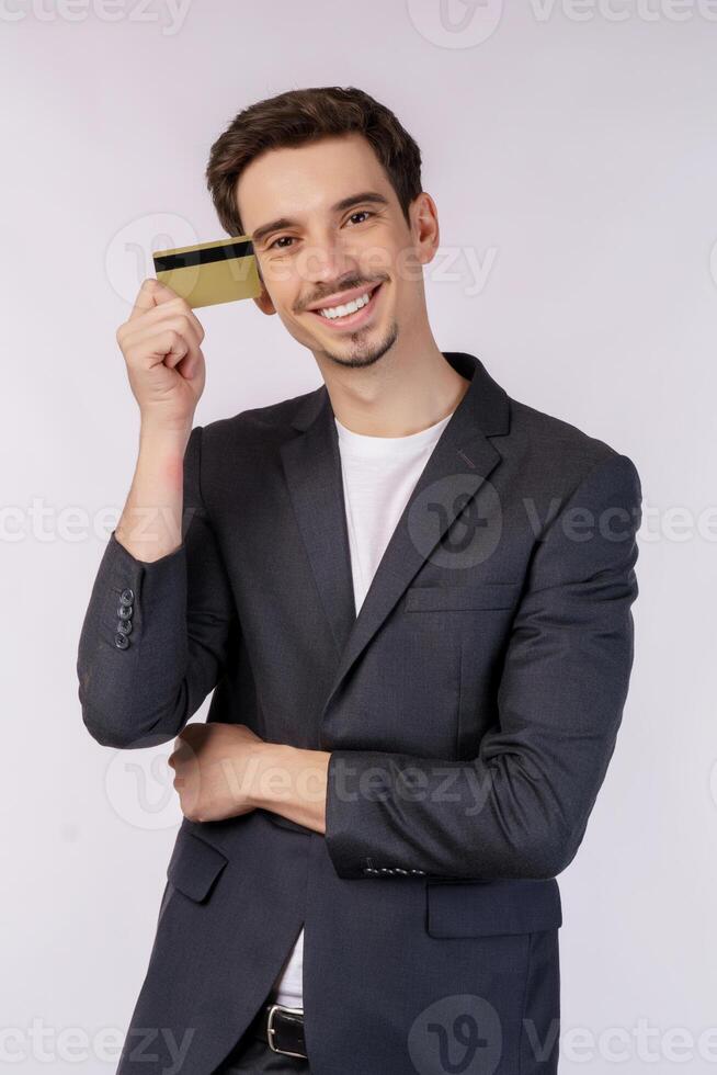 Portrait of Young smiling handsome businessman showing credit card isolated over white background photo