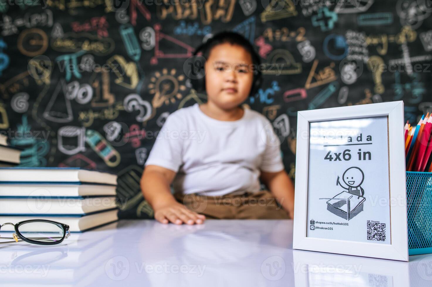 Child sitting with photo frame in the classroom