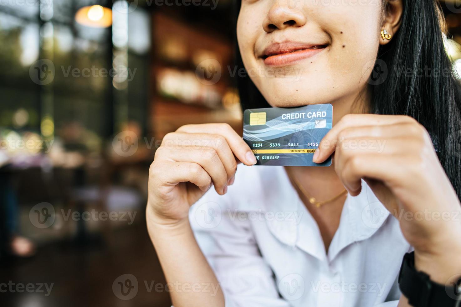 mujer sosteniendo tarjeta de credito foto