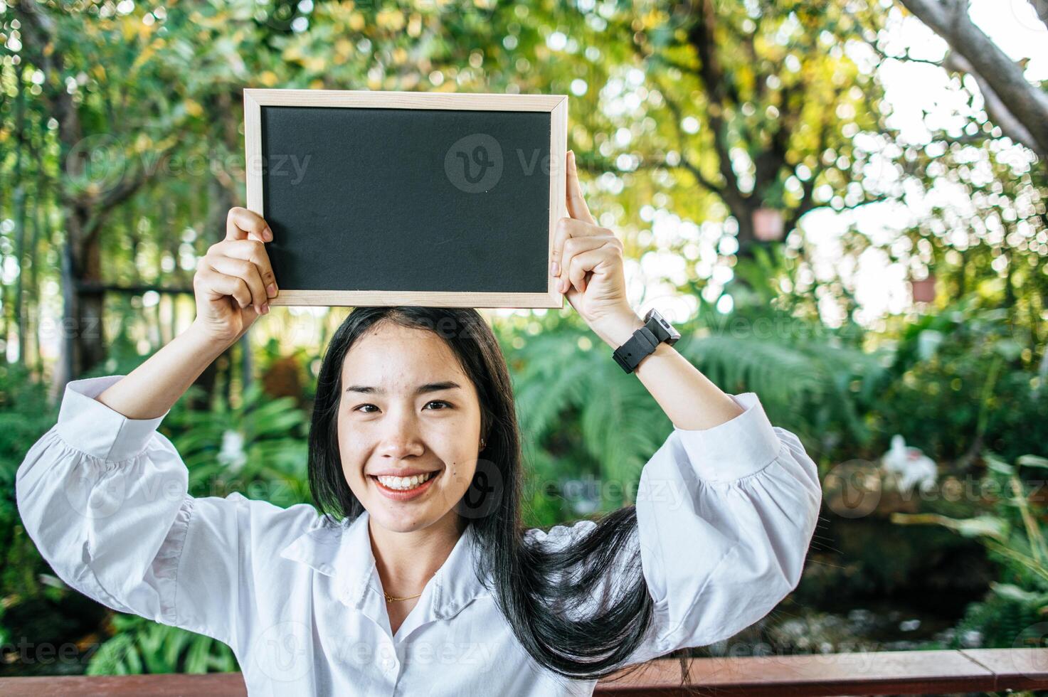 woman holding blank blackboard photo