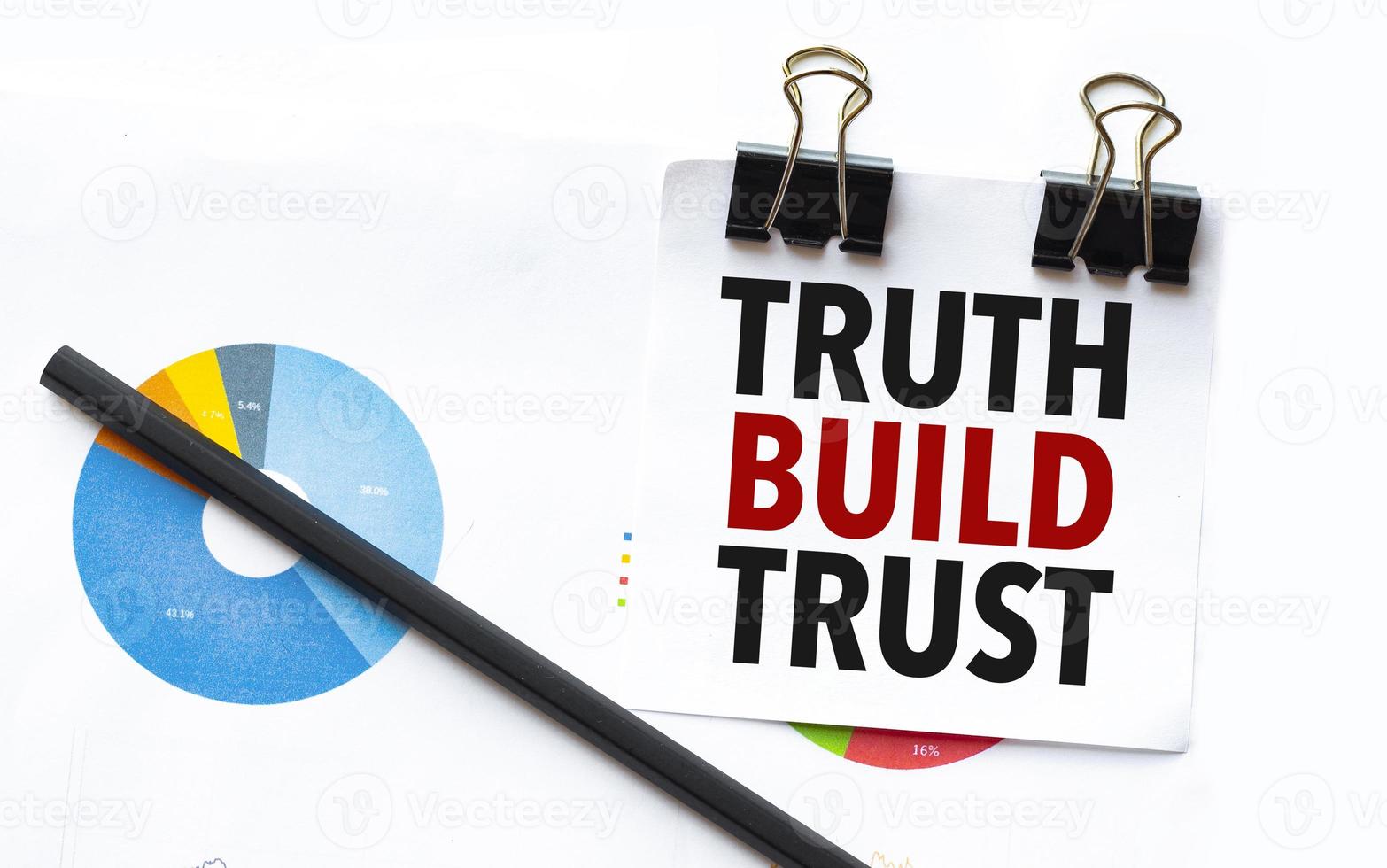 truth build trust on notebook with charts and pencil photo