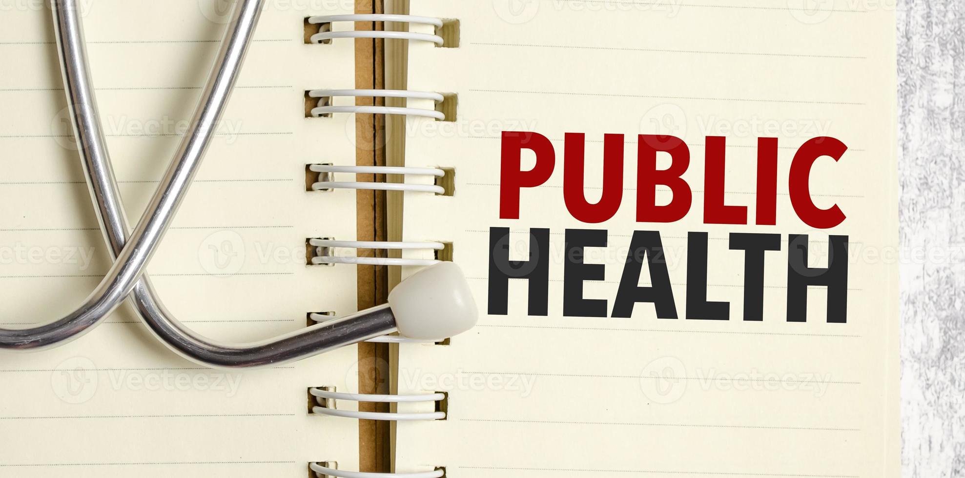 Stethoscope and notebook with public health text on notebook photo