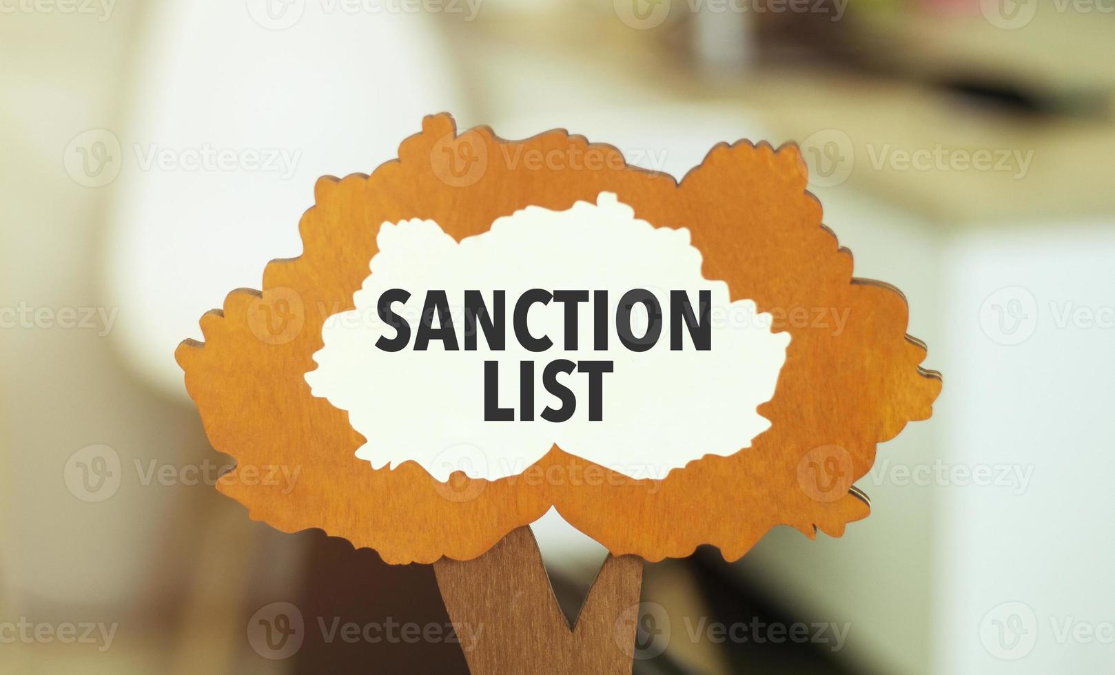 figure of a tree with text sanction list inside the foliage. Business concept financial tables with a pen. photo