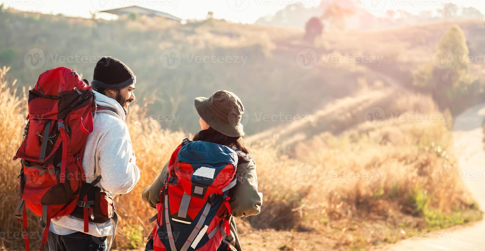 traveler couple with backpack standing looking view on mountain photo
