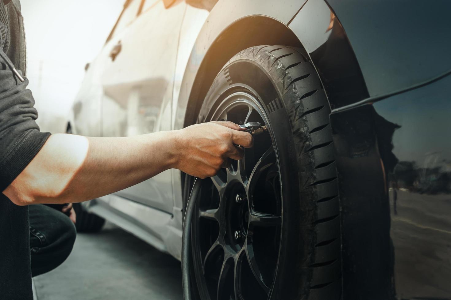 hand inflating tires of vehicle. checking air pressure and filling photo