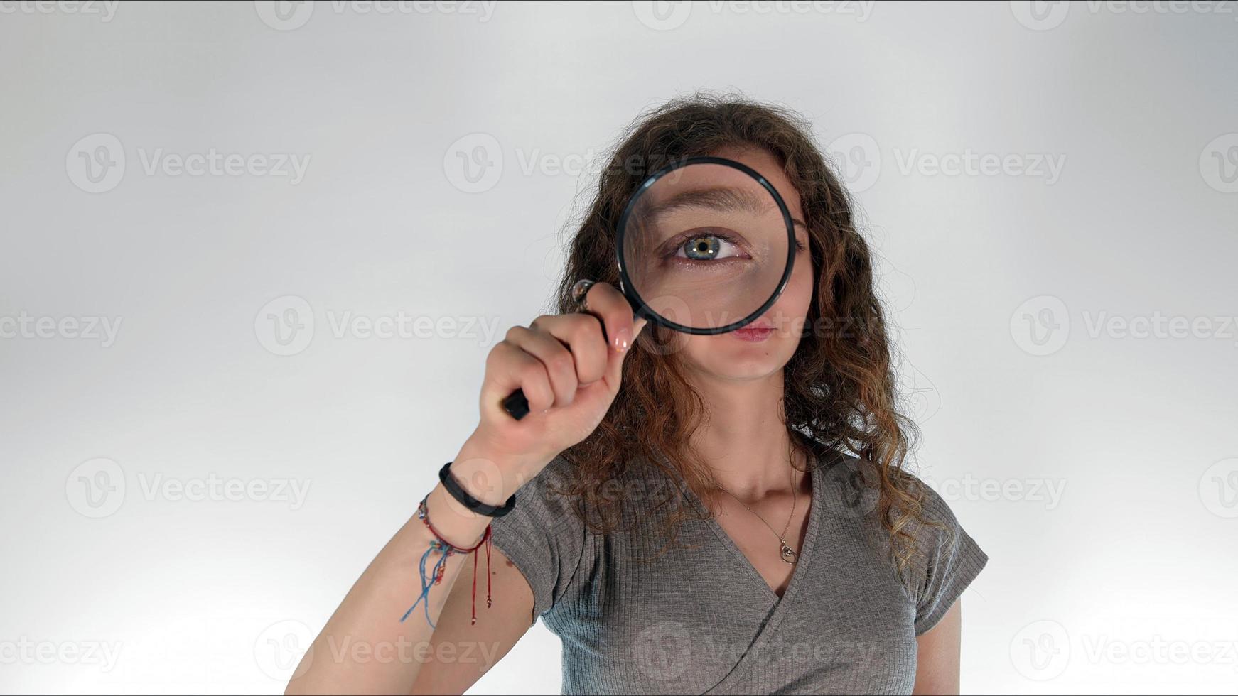 Young girl holding a magnifying glass photo