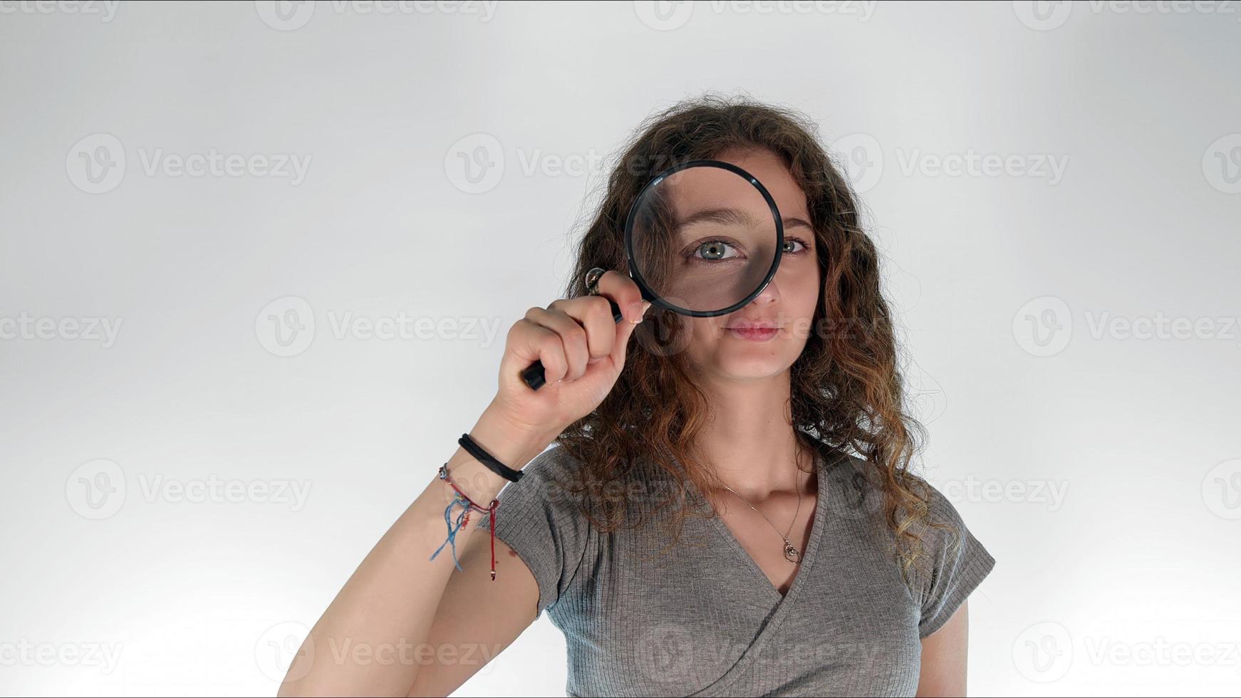 Young girl holding a magnifying glass photo