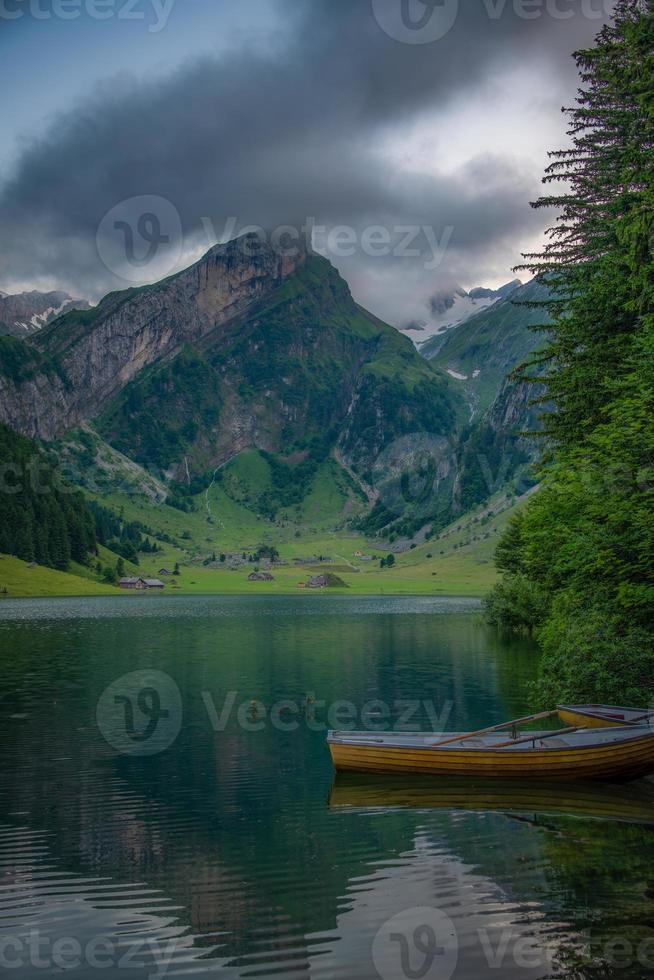 un montaña lago con barcos en un hermosa montaña, en nublado clima foto