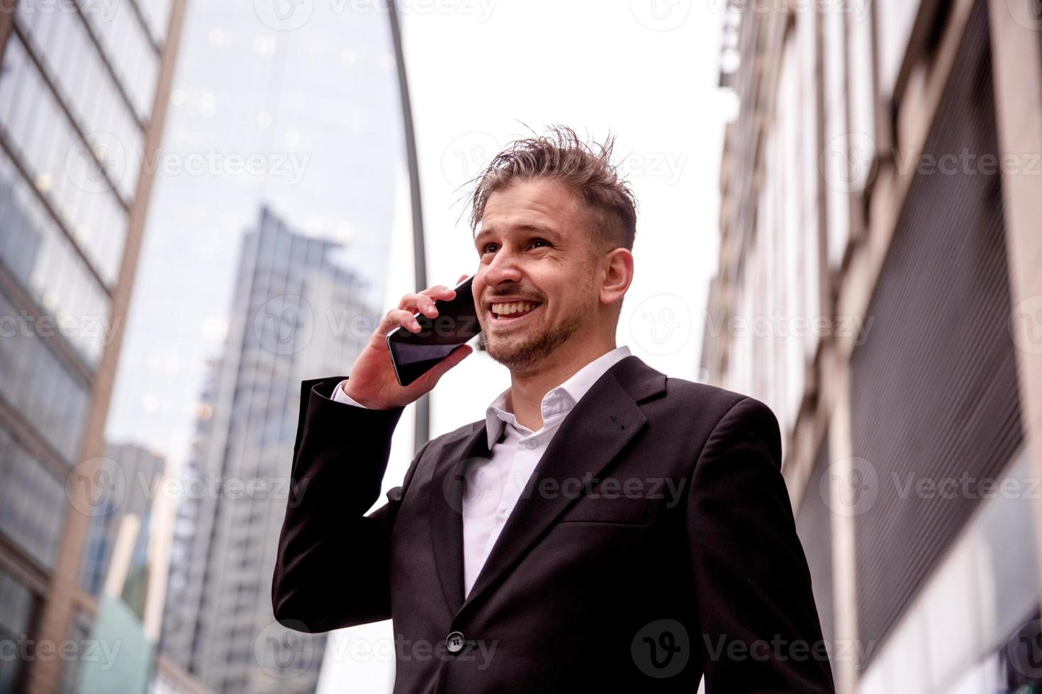 guy in a suit talking on the phone smiling photo