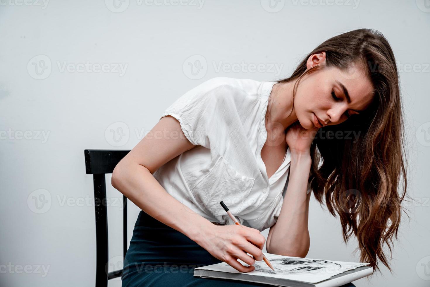 Girl sitting on a chair draws a sketch for a picture photo