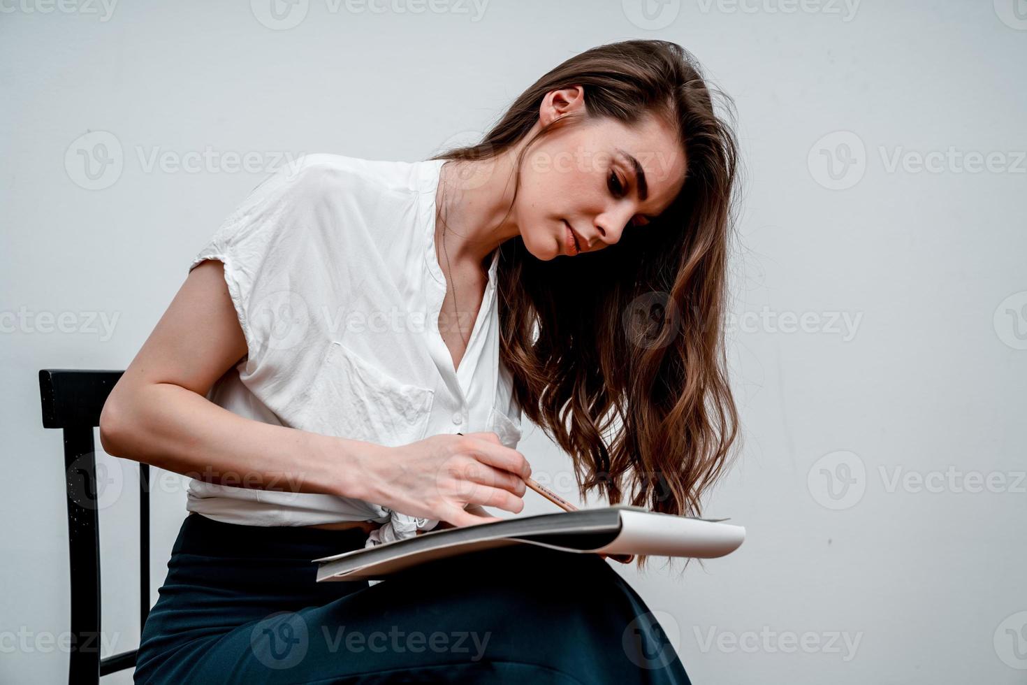 Girl sitting on a chair draws a sketch for a picture photo