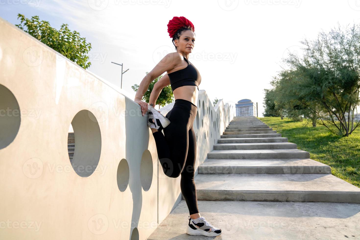 Exercise, stretching and a woman at gym for fitness workout for health and body wellness with muscle warm up. Sports female or athlete stretch legs at window for balance, energy and healthy lifestyle photo