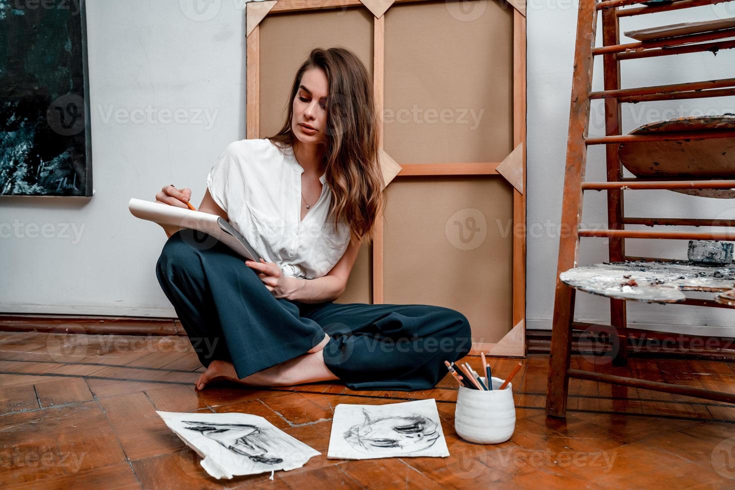 portrait of a beautiful young artist, draws pictures in the workshop photo