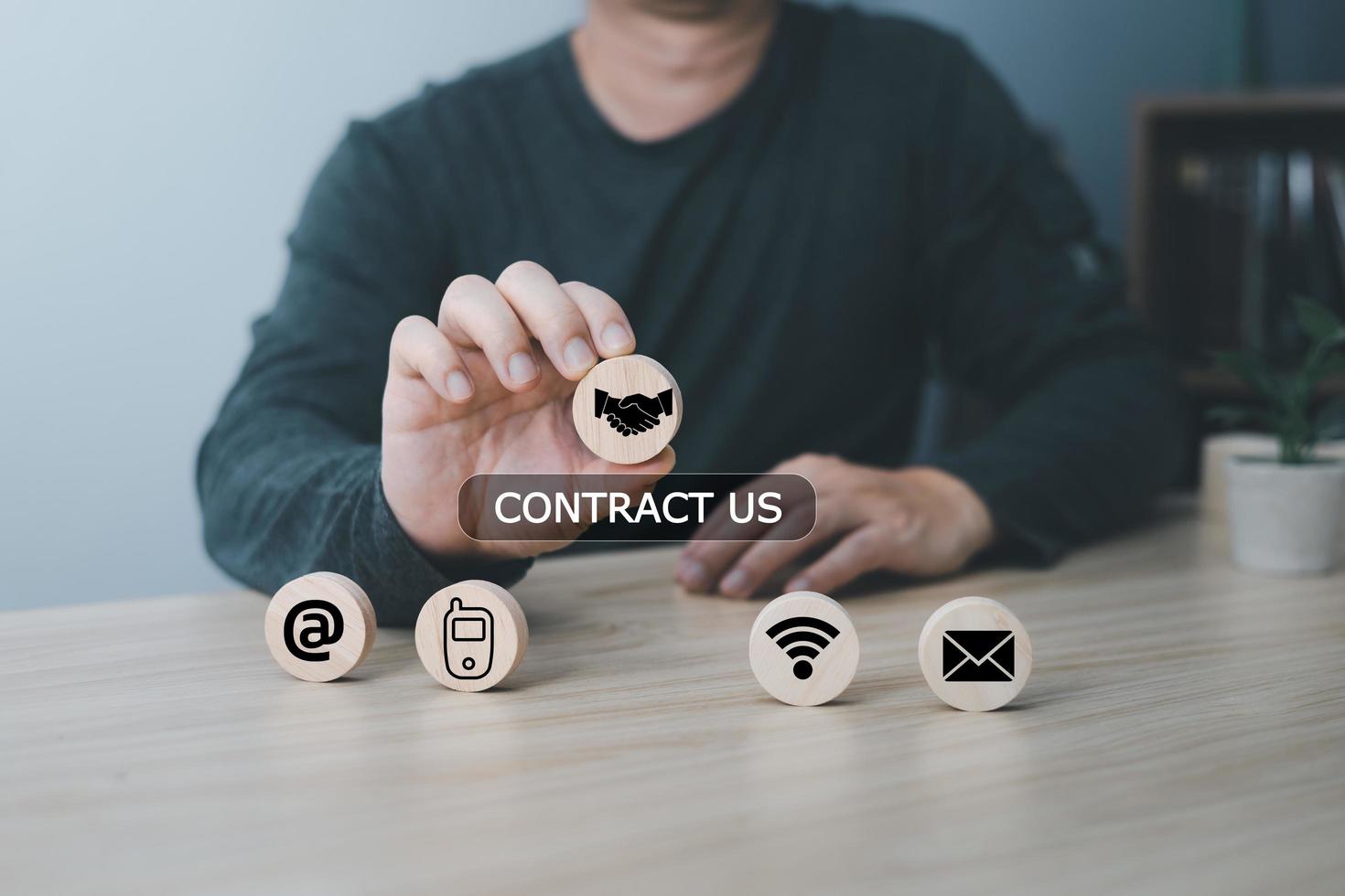 Hand of a businessman chooses contact icons address,phone,wifi,email on wood block circle,Contact us and Customer support hotline people connect. photo