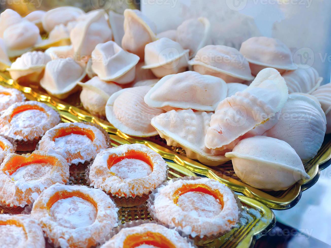 Selective focus of traditional Portuguese egg yolk sweets name Ovos Moles de Aveiro, sweet snack, on gold color tray, selling in the pastry shop, Portugal photo